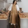 NUSS Linen Retro Apron in natural 100% linen with pockets and adjustable straps, handmade in Latvia